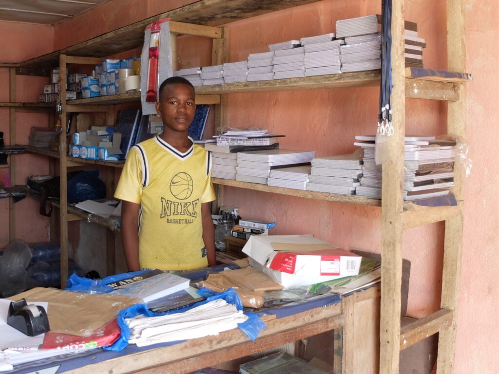 En ungdom fra Liberia som står i sin egen butikk.